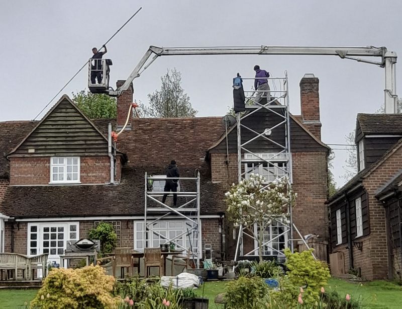 The Moss Cleaners using cherry picker and scaffolding to clean roof safely and professionally in Haywards Heath, West Sussex